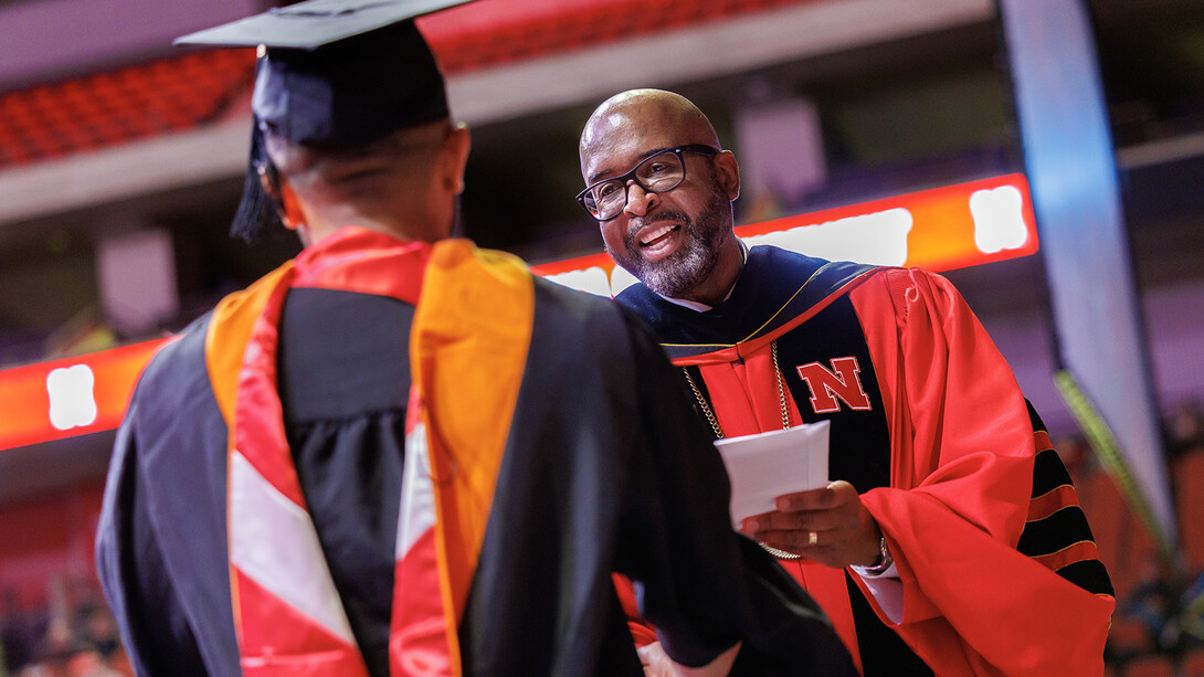 Chancellor Rodney D. Bennett hands a student their master's degree during commencement on Dec. 20, 2024.