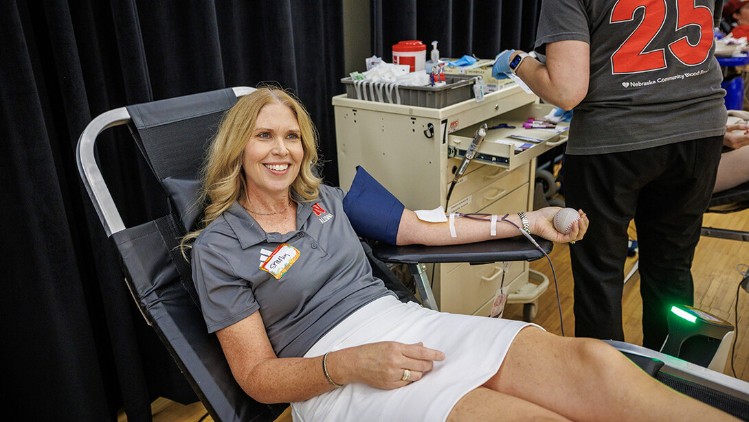 Shelley Zabarowski is seated giving blood in Nebraska Union during Homecoming 2025.