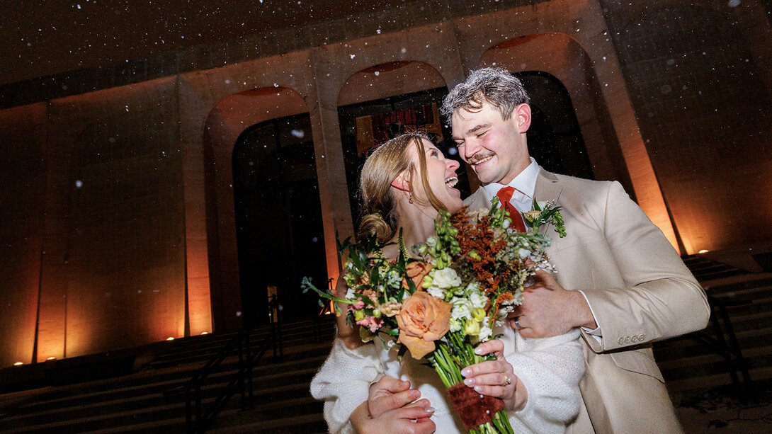 2024 alum Rachel Swanson takes advantage of the snow by taking photos with her newly-wed husband Luke Swanson outside the Sheldon Museum of Art.