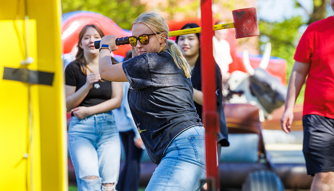 Claire Gangwish, prepares to hit the Highstriker’s bell will a hammer during the End of Year Bash on East Campus.