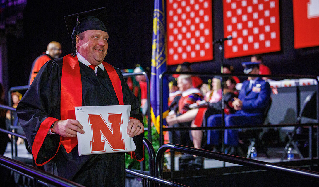 Corrie Svehla, the Assistant Director of Special Events for UNL walks down the stage after receiving his diploma.