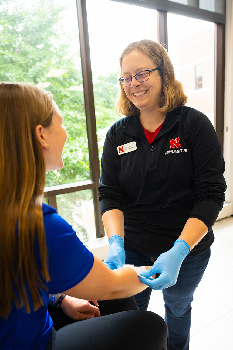 Jen Krueger, senior coordinator for injury prevention and care, smiles at Kelci Davis, one of her student workers in the Injury Prevention and Care office on the second floor of the Campus Recreation Center.
