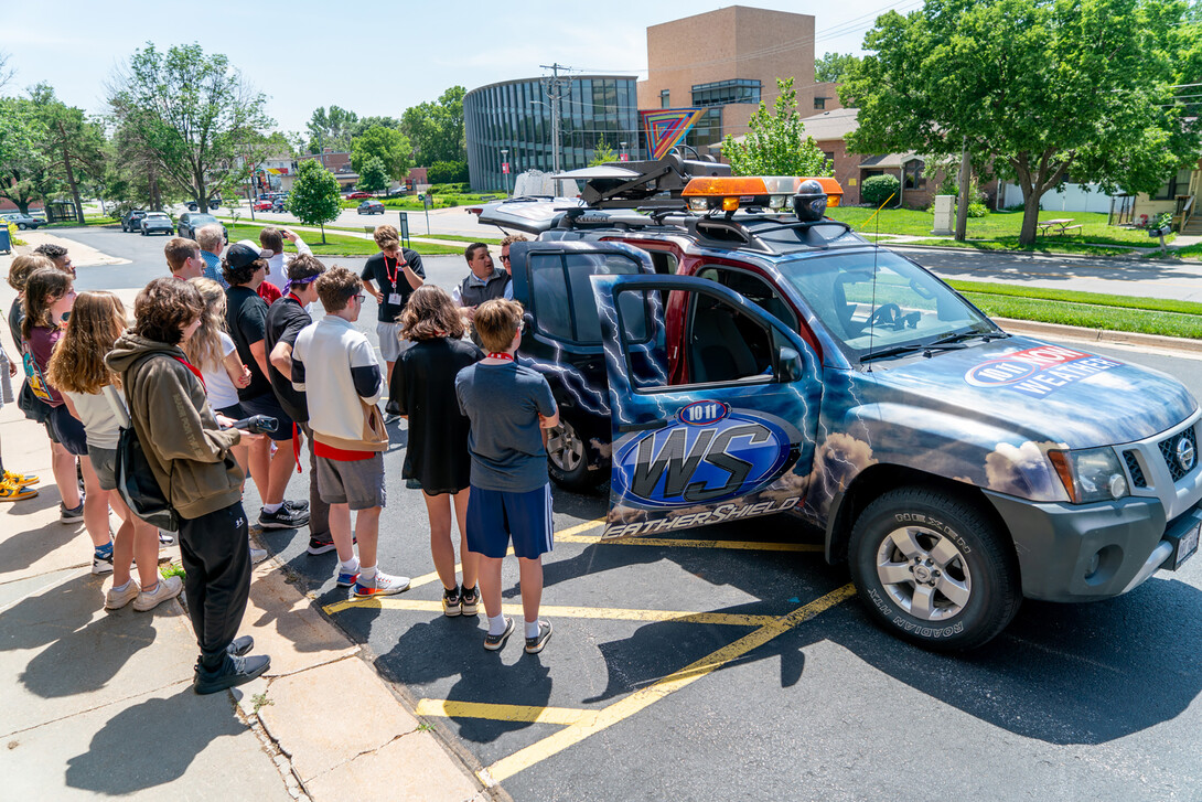 Meteorologists from 10/11 meet with students and explain some of the equipment they use to forecast and track the weather.