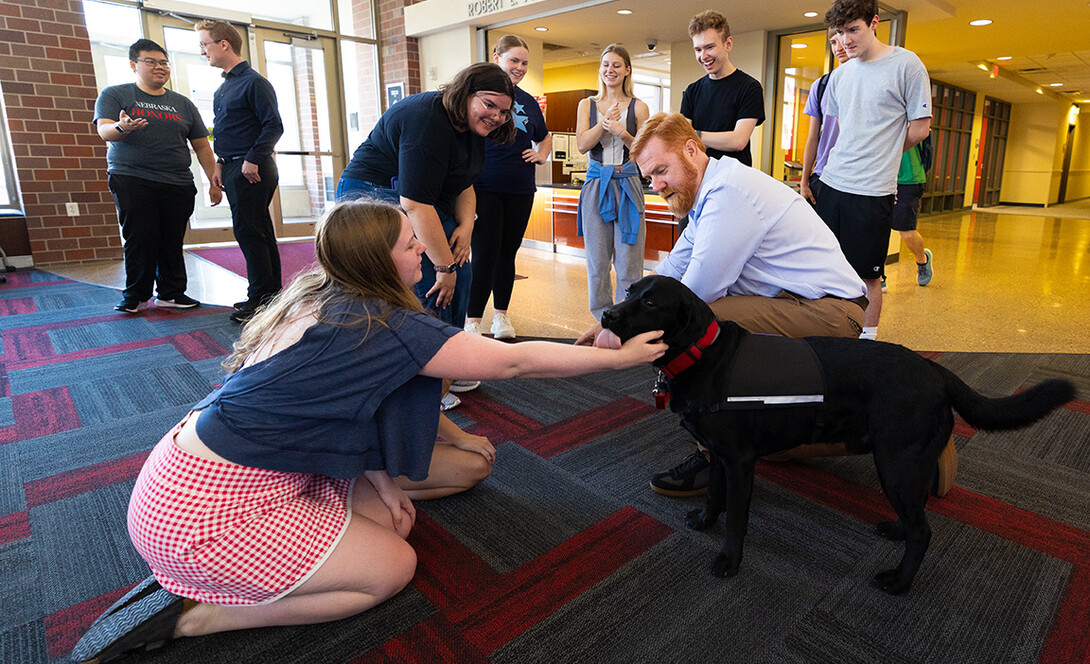 Students in the Honors Program smile as Jax, the program's therapy dog, gives a kiss to Emily Hughes, a first-year student majoring in forensic biology and pre-med.
