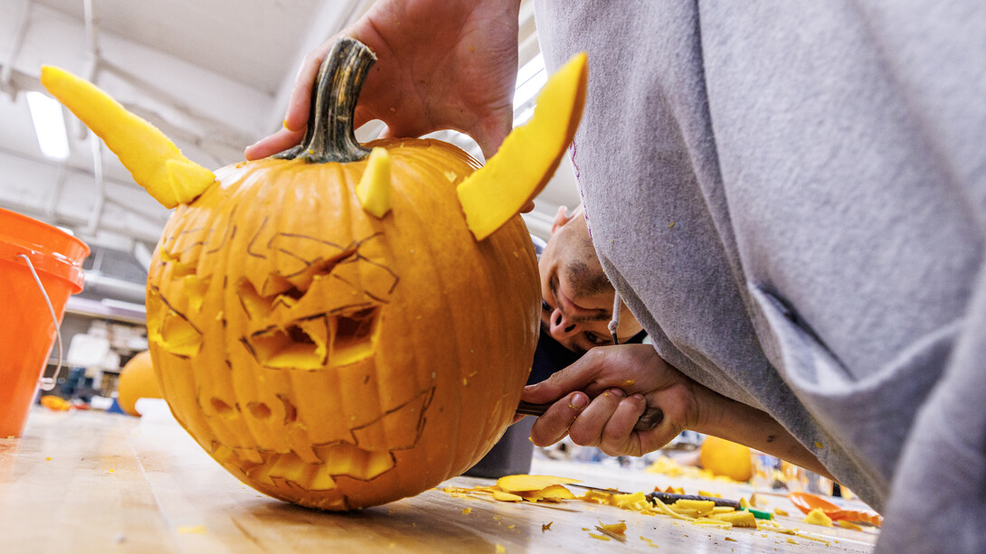 Israel Mendez, a senior art major, works on his pumpkin during the Sculpture Club’s pumpkin carving meeting inside Richards Hall on Oct. 29. Students and staff from the School of Art, Art History and Design created a variety of designs, showcasing their creativity in hands-on activities.