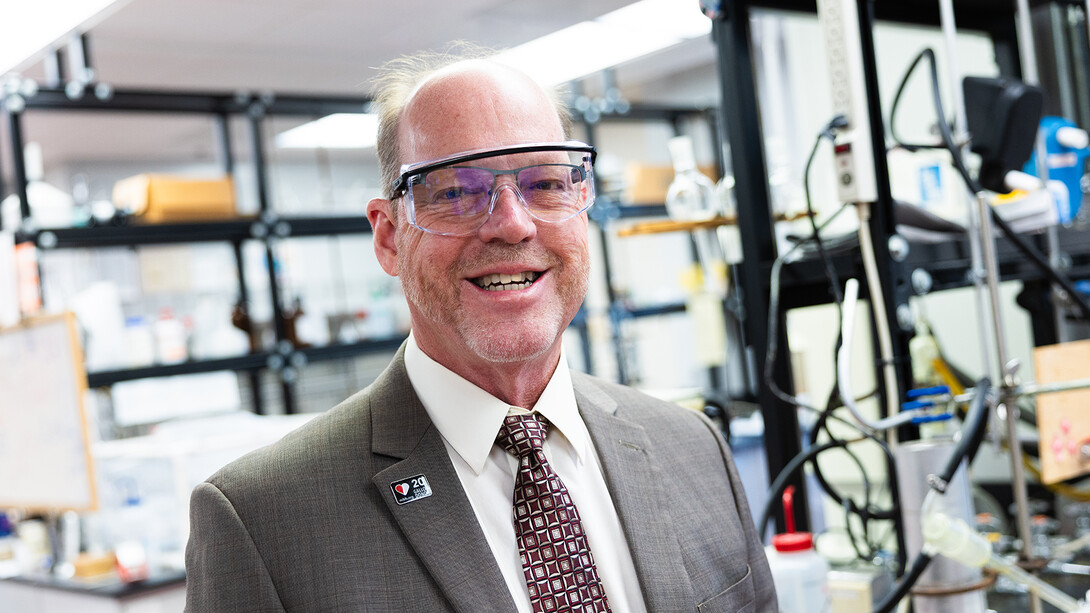 Pat Dussault stands in his Hamilton Hall lab. He is wearing a 20-gallon blood donation pin.