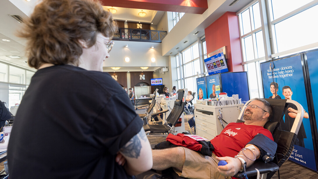 Brian Amato, Associate Head Coach of Women’s Gymnastics, talks to a nurse as he gives blood during the We Give Blood Drive inside Memorial Stadium. Nov. 14, 2025.
