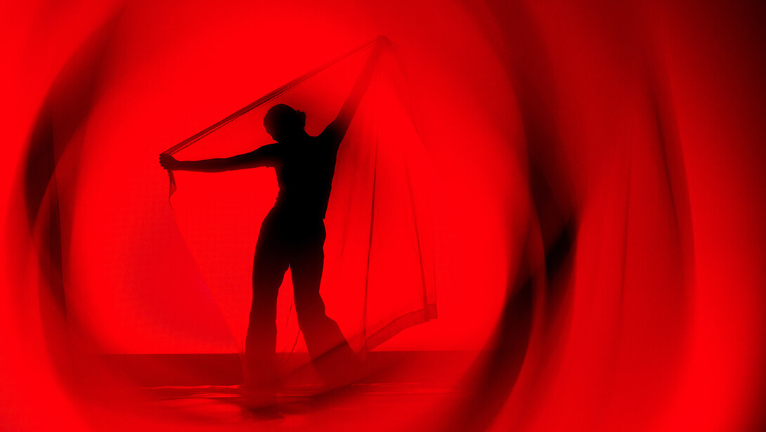 A dance is lit in red during a performance.