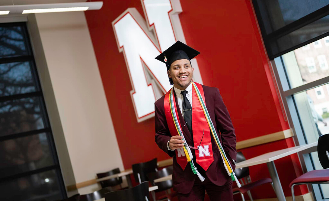 Ra'Daniel Arvie poses for a photo in his mortar board and honors cables.