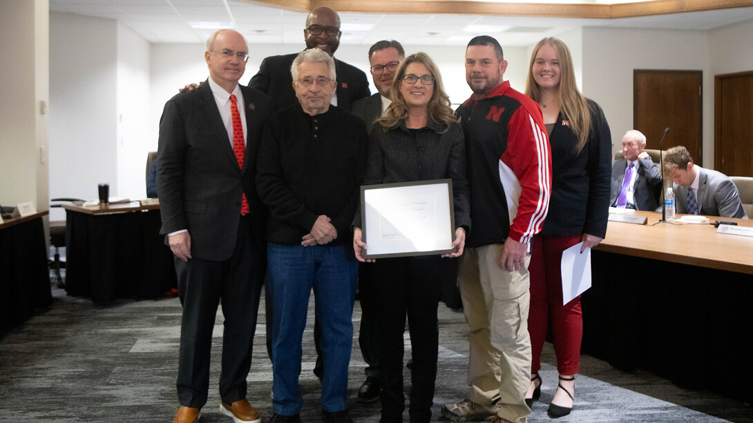 Tricia Besett-Alsech poses with family and university leaders after being presented with the Kudos award during the Dec. 6 meeting of the NU Board of Regents.