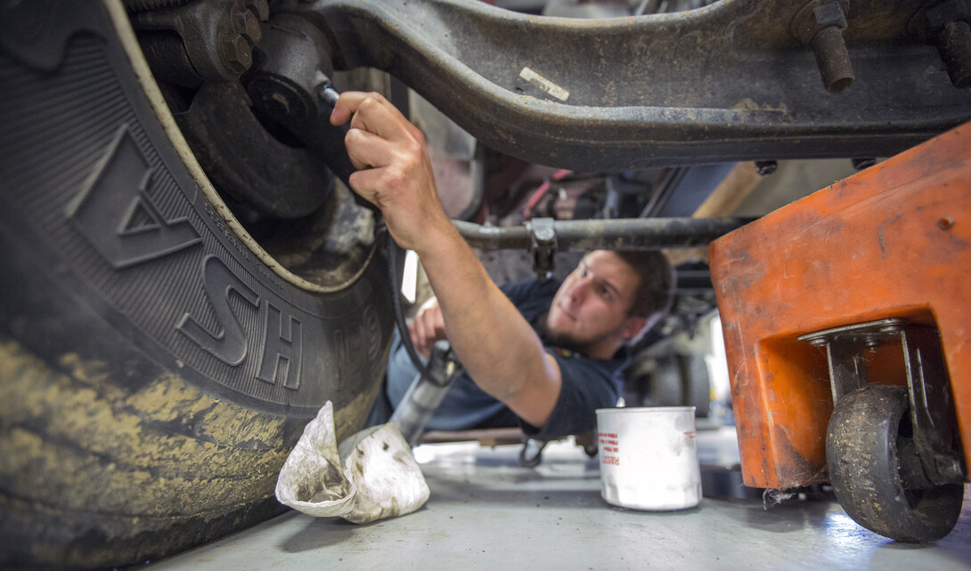 Jacob Green, a mechanic II, lubricates the chassis of a university delivery truck at the Transportation Services garage on City Campus.