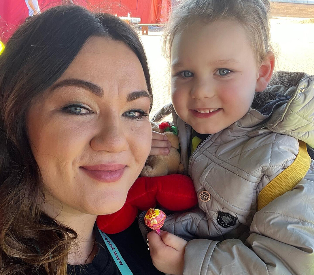 Tatyana Gulchuk holds Arisha, a child from Mariupol, at a refugee assistance center along the border with Poland.