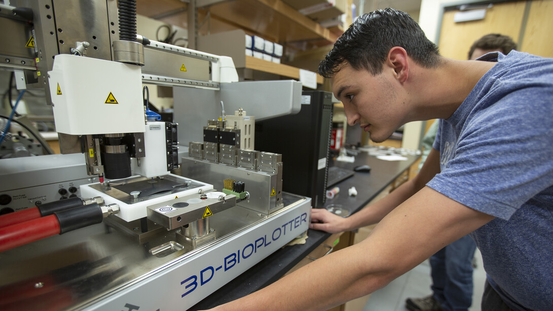 Tyrell Williams, a senior biological systems engineering major from Colorado Springs, Colorado, watches as a 3D-Biolplotter prints a structure using silicone. The bio-printer will soon be joined by a second in labs led by Nebraska's Ali Tamayol.