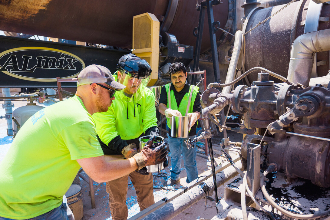 Nitish Bastola, PhD Civil Engineering student at UNL, collects oil samples for study with the help of Max Venne (middle), lab technician with Barkley Asphalt, and Eric Barkley (left) plant manager at Barkley Asphalt.