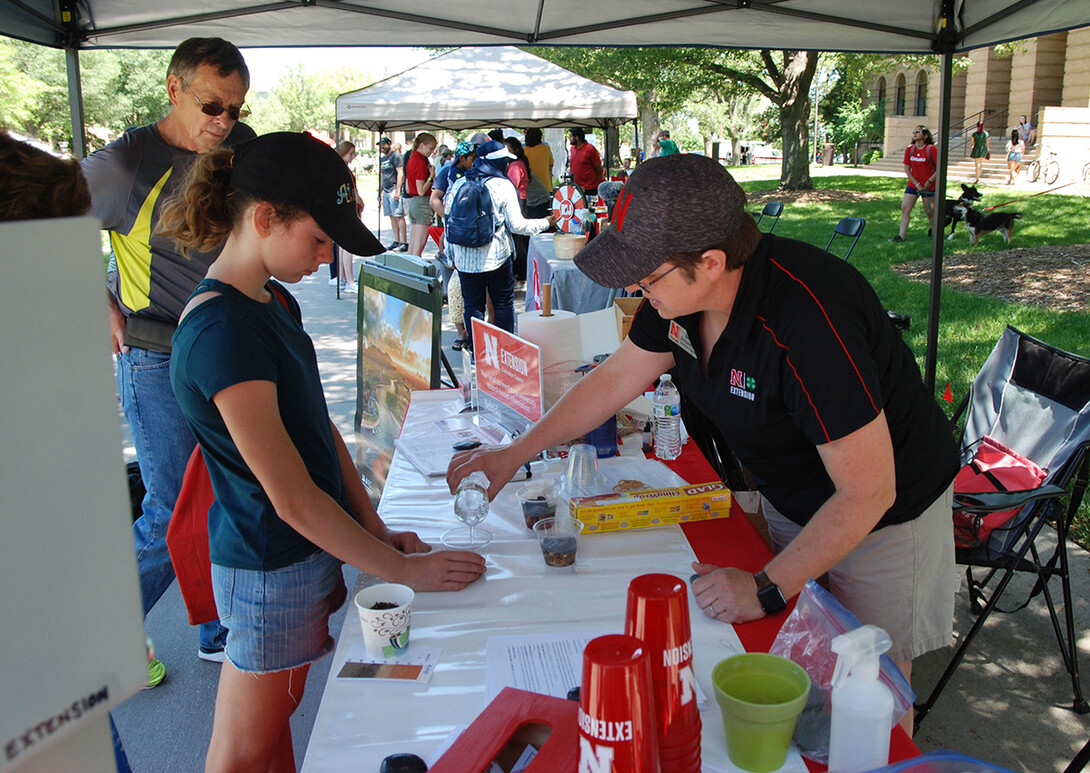 Pictured is Extension Associate Becky Schuerman (right) who serves as Extension’s statewide domestic water and wastewater coordinator, presenting aquifer in a cup. 