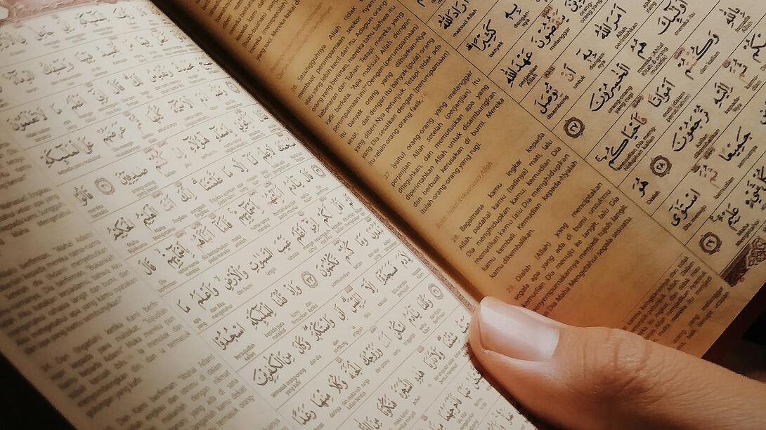 A woman reads text from the Quran.