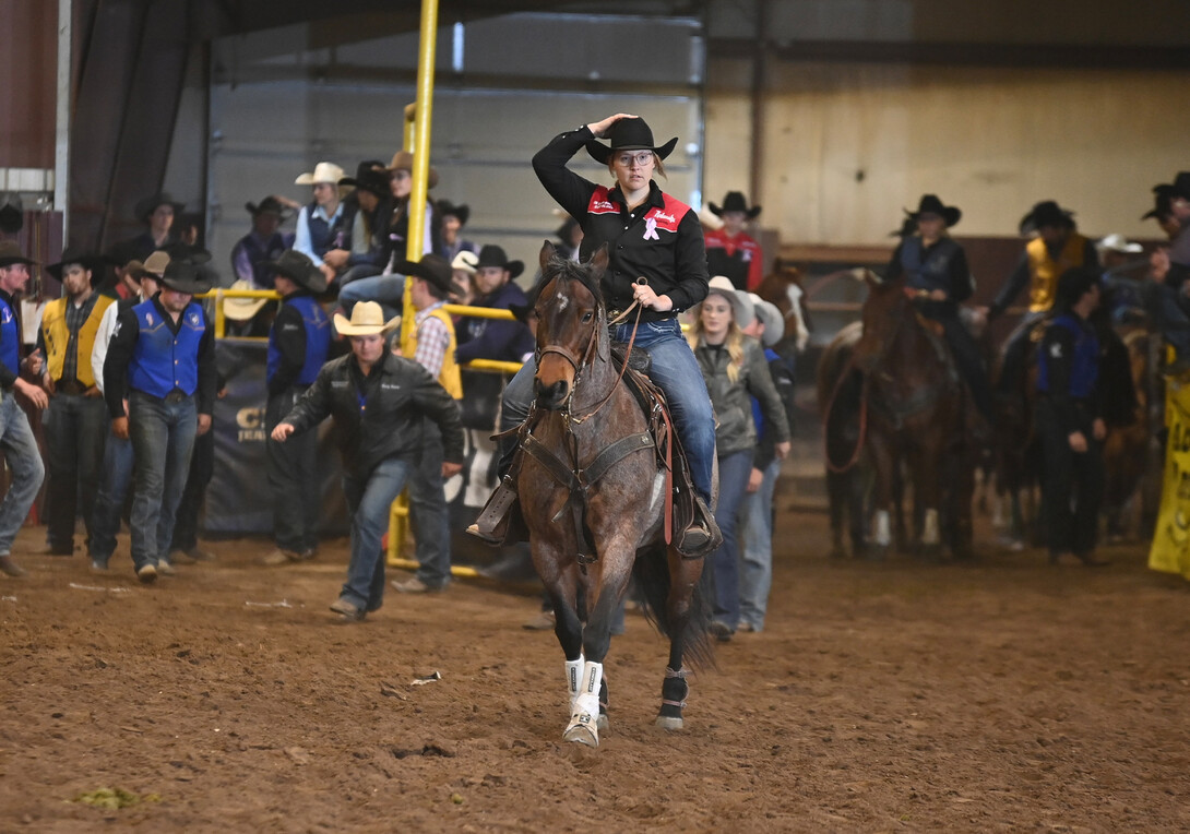 Jaya Nelson rides a horse at an indoor rodeo.