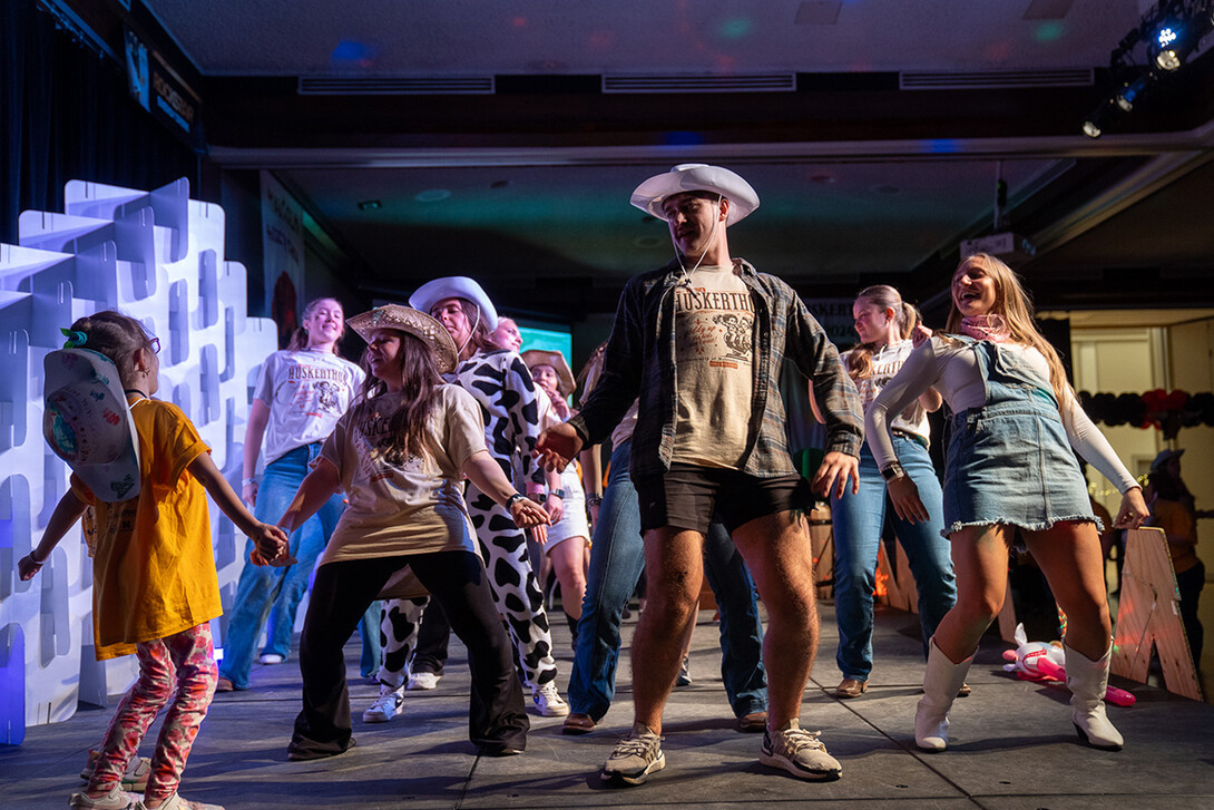 Eli Hiser (center) and Ella Jepsen (right) lead a line dance at HuskerThon.