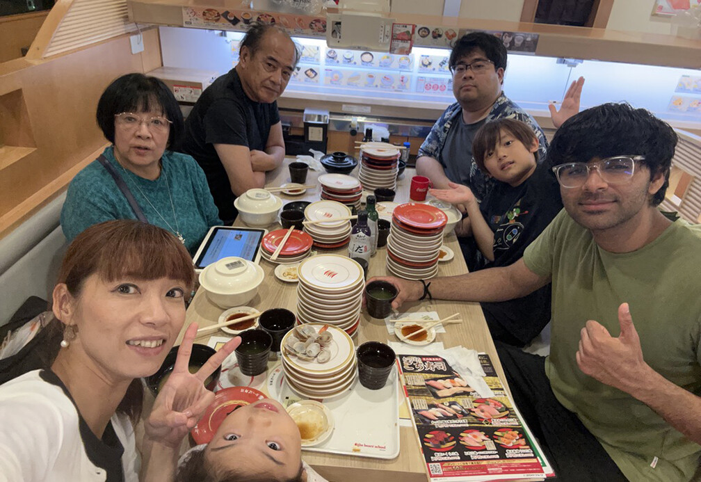 Student posing with a family in Japan.