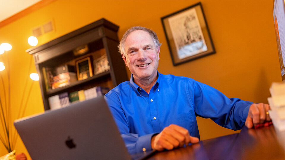 Ken Kiewra sitting in front of laptop computer