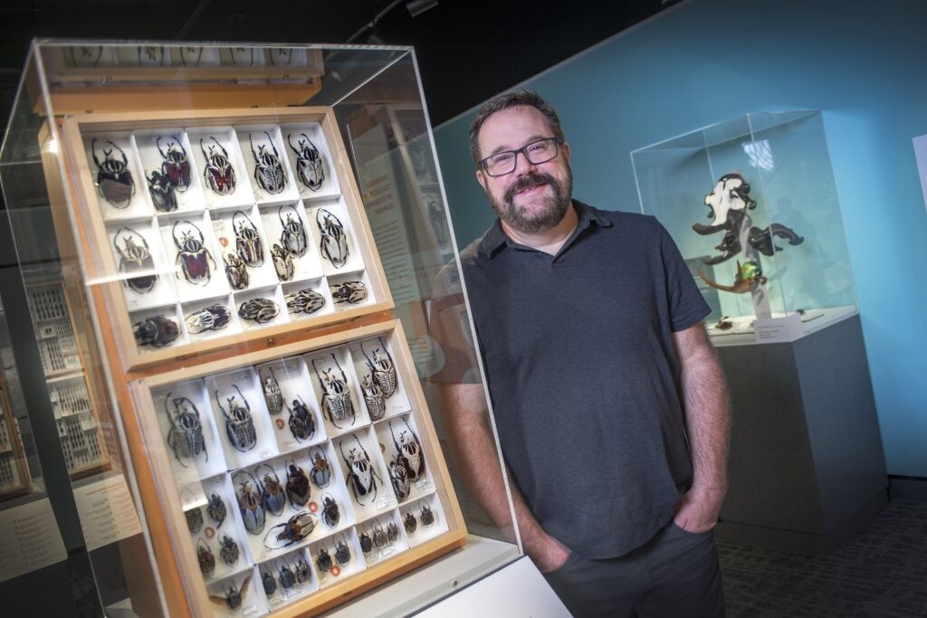 MJ Paulsen stands by a large display of very large insects.