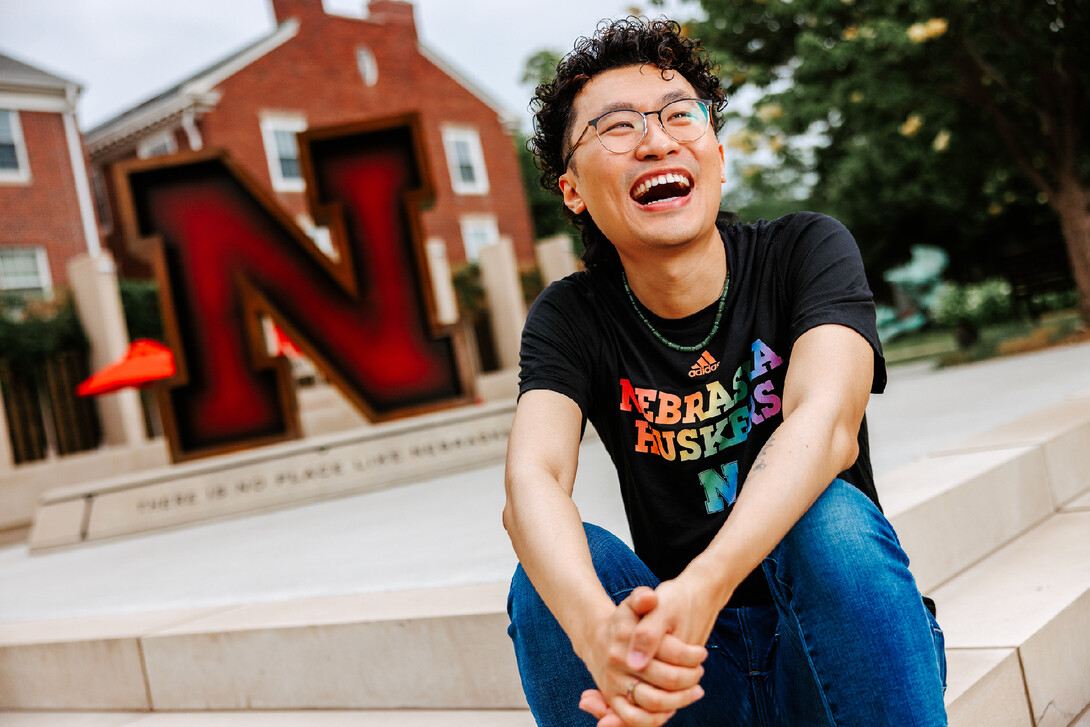 Nathan laughs for a photo on the stairs of the Wick Alumni Center