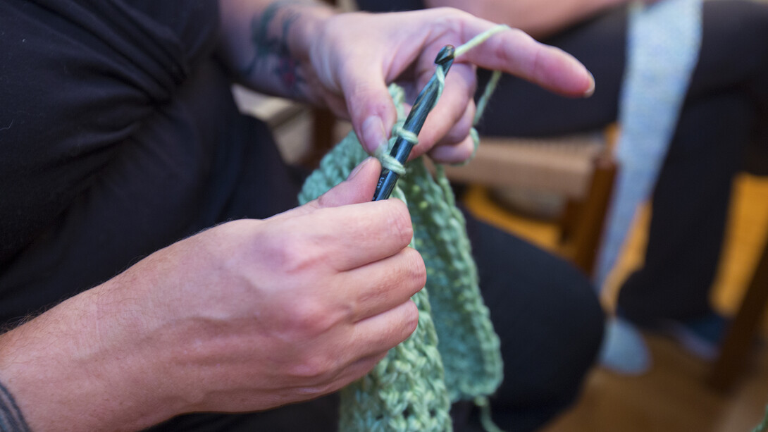 Amy Green, owner of Lincoln's Ivanna Cone, uses crochet hooks to craft a scarf during the Nov. 20 volunteer event. The group is working to make as many scarves as possible by Dec. 10 for McPhee Elementary School students.