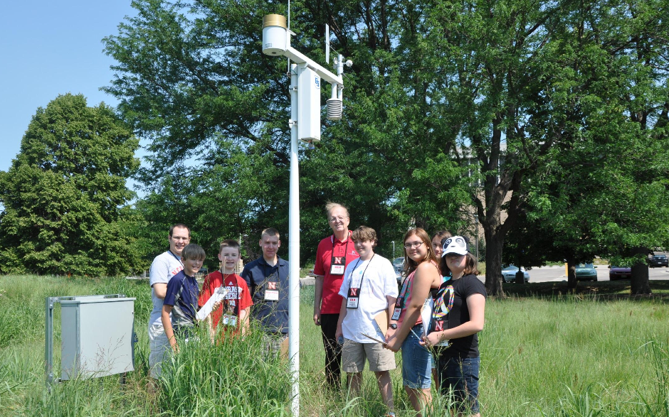 Ken Dewey and youth examine a weather monitoring station during the 2012 weather camp on East Campus.