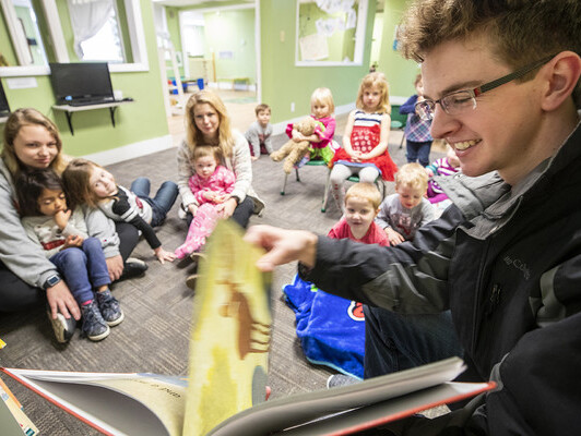 Thomas Kerr, a senior accounting major from Hastings, reads to children at the Foundations Progressive Learning Center during the Husker Reading Challenge.