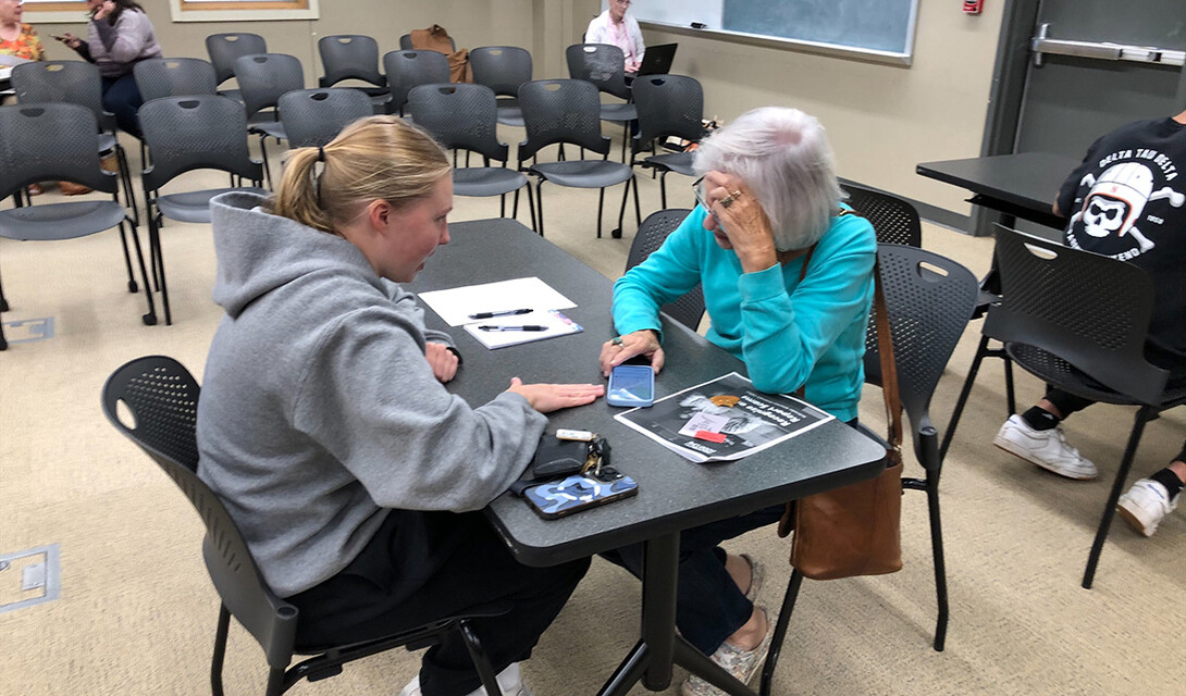 Student Norah Deckert works with a Lincoln resident at Aging Partners.