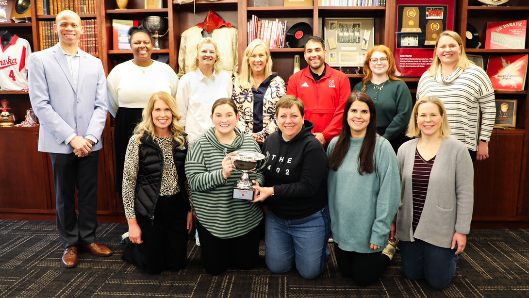 Members of the Nebraska Alumni Association pose with Lawrence Chatters and the Chancellor's Cup after winning the Small Office Division of the 2024-25 United Way campaign.