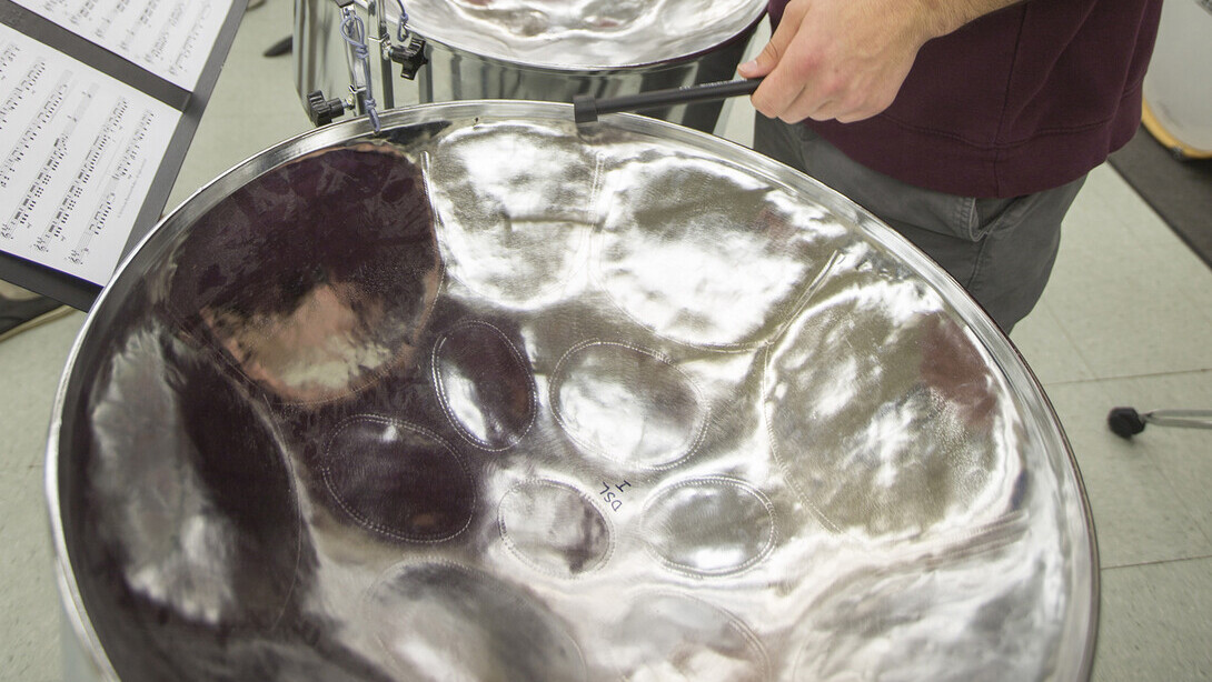 Close up image of a student playing a steel drum.