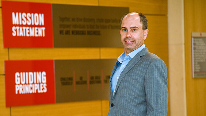 Julian Atanassov stands in a grey suit and light blue button up shirt.