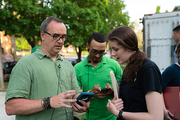 J.B. Tyson (first assistant director, left) visits with Carson School students Adam Turner and Candace Nelson to set up a shot for "The Healing of Harman." Photo by Jordan Opp.