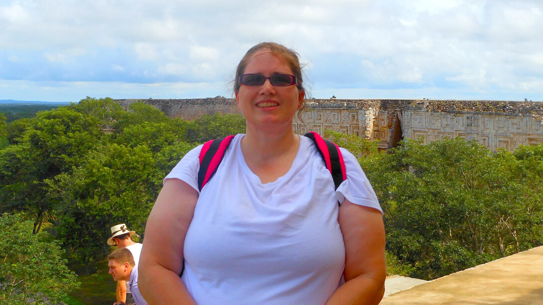 Image of Amy Sue Peterson posing with archaeological ruins in the background.