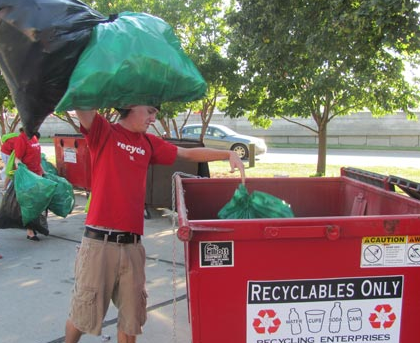 A volunteer places recyclable materials in a bin during the 2011 game against Michigan State.