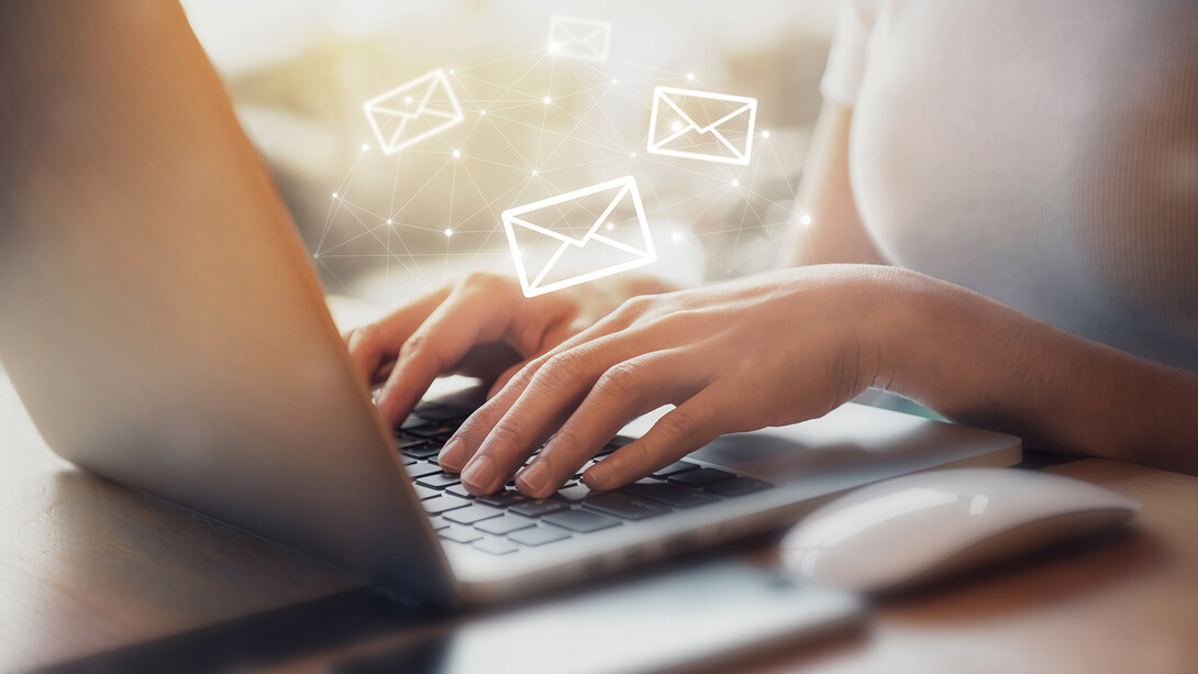 photo of hands on a laptop keyboard with animated email envelopes flying about.