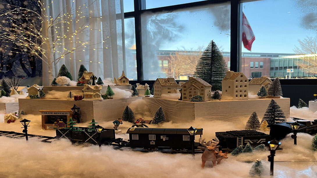 A winter village set up in front of storefront windows.